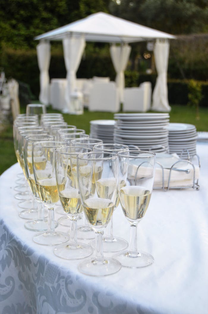 Champagne glasses and plates set on an elegant table for an outdoor wedding in Queluz, Portugal.